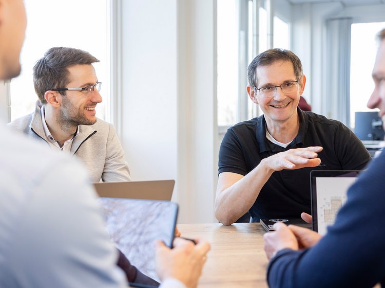 Zwei Männer im Gespräch über Energiemanagement, professionelles Umfeld