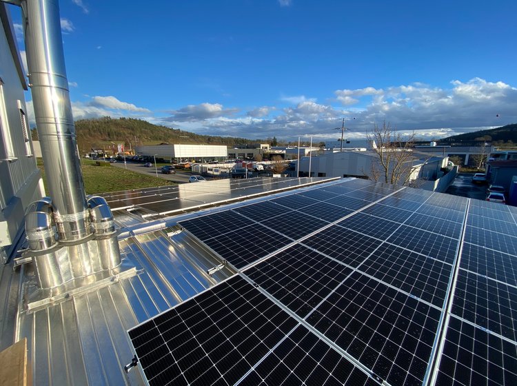 Solarpanels auf einem Firmengebäude mit klarem Himmel im Hintergrund