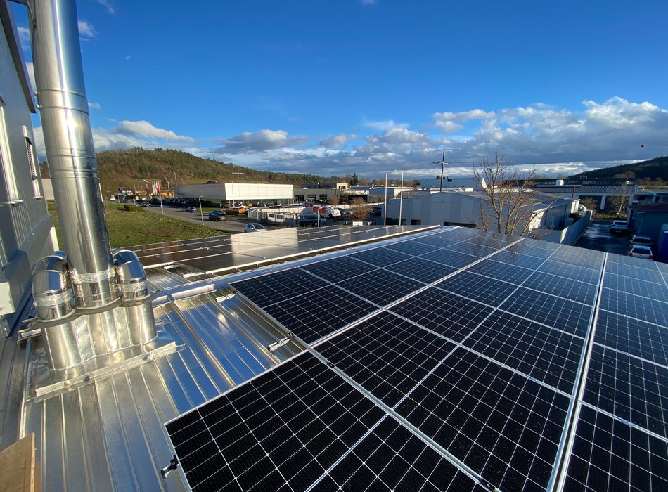 Solarpanels auf einem Firmengebäude mit klarem Himmel im Hintergrund