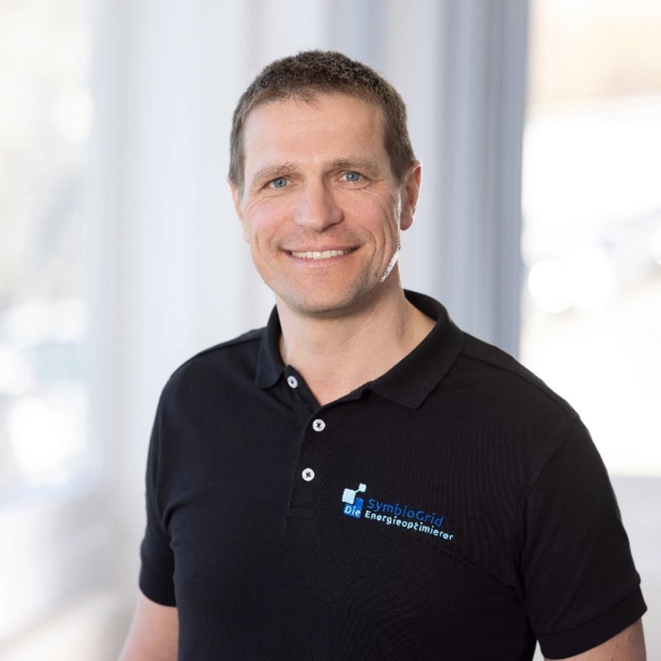 orträt von Marco Umbreit, Geschäftsführer von SymbioGrid, mit schwarzem Polo-Shirt